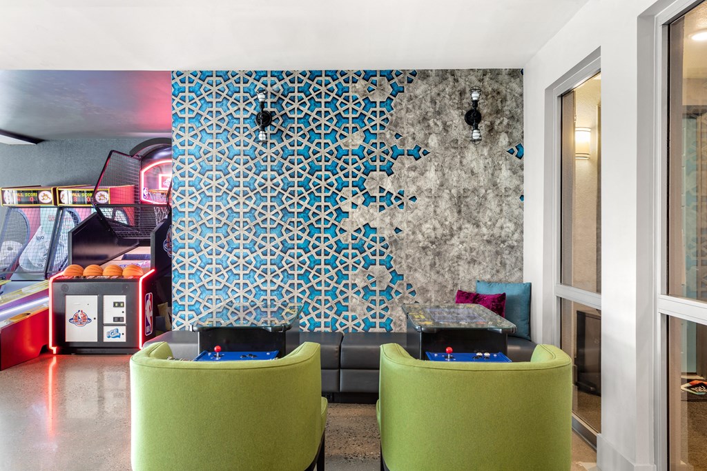 a living room with green chairs and a mural on the wall