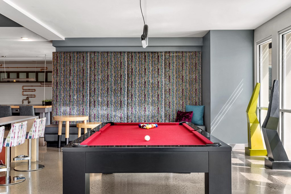 a red pool table in a living room with a colorful wall