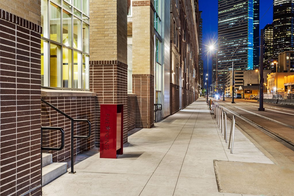 a city street at night with brick buildings and a sidewalk