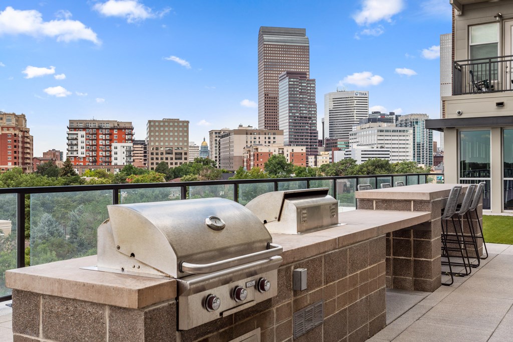 a grill on a balcony with a city in the background