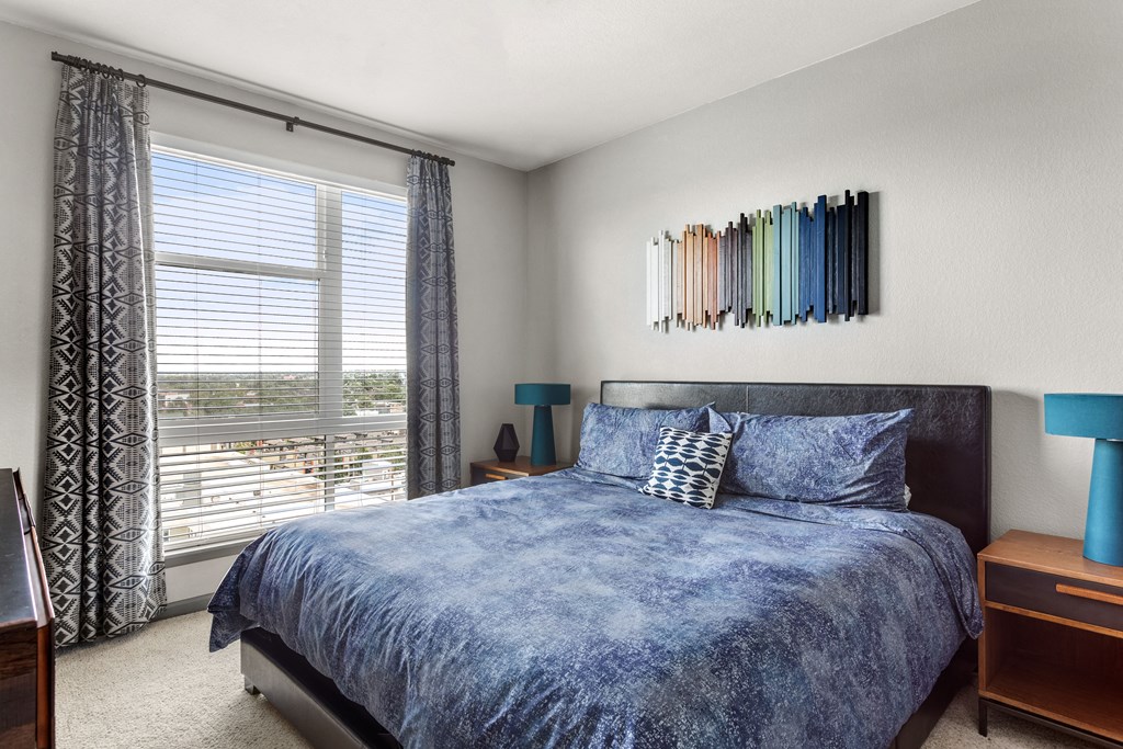 a bedroom with a bed and a large window