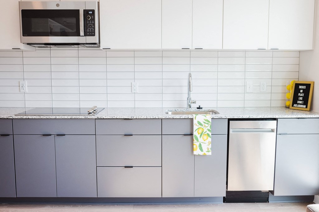 a kitchen with white cabinets and a sink and a microwave
