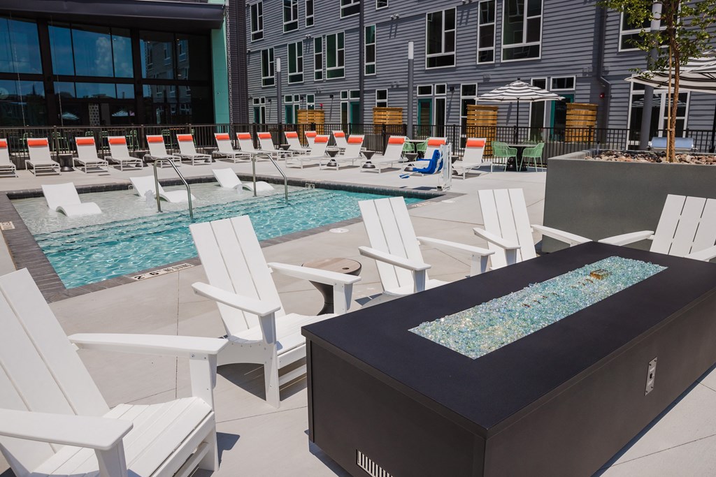 a poolside table and chairs next to a swimming pool