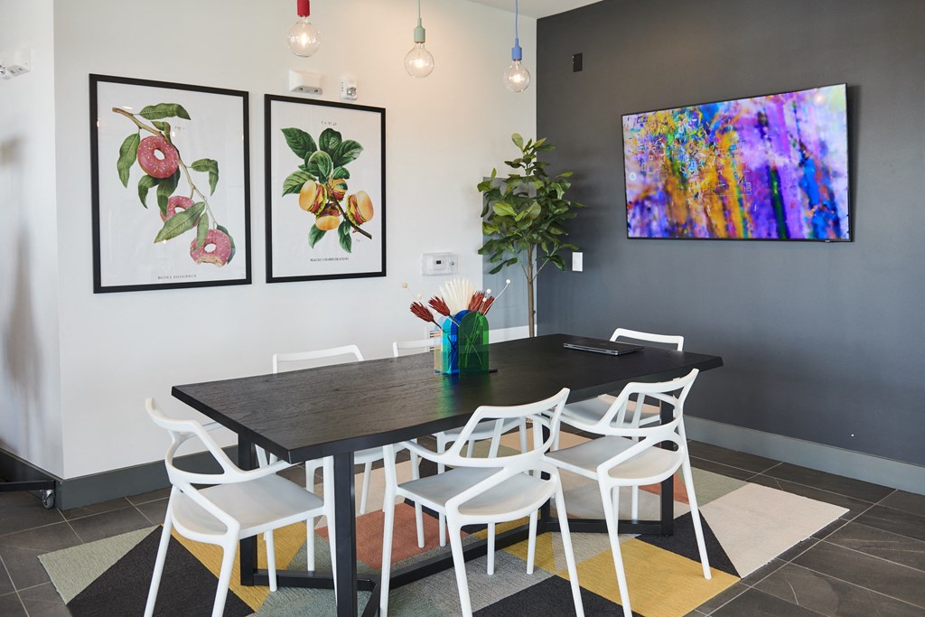 a dining room with a table and chairs and paintings on the wall