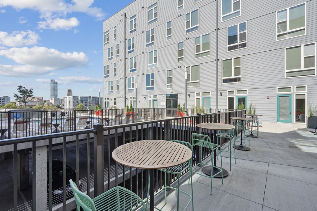 a patio with tables and chairs in front of a building