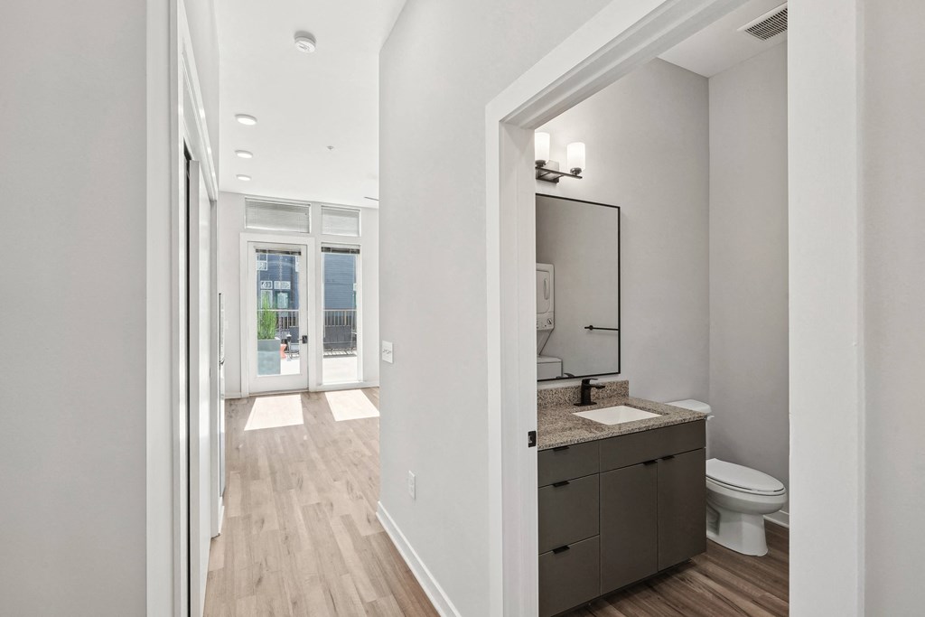 an open bathroom with a toilet and a sink and a mirror