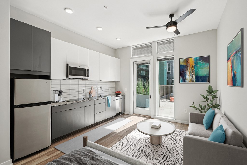 an open living room with a kitchen and a sliding glass door