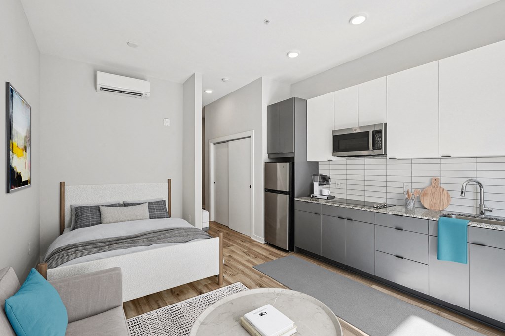 a bedroom with a bed and a kitchen with a sink
