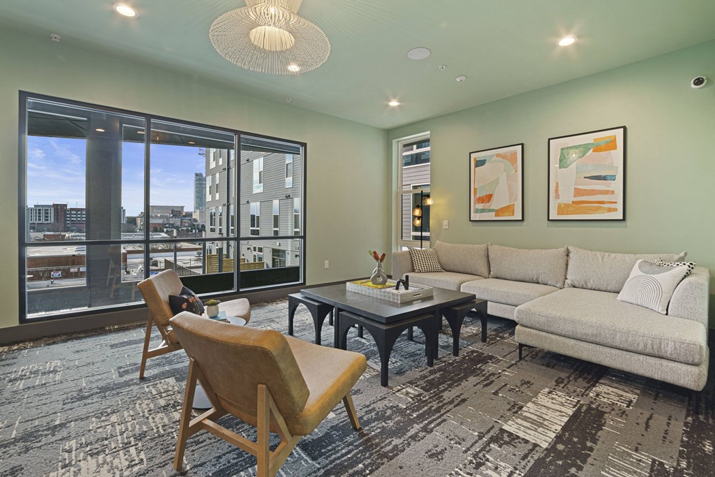 a living room with a couch and chairs and a large window