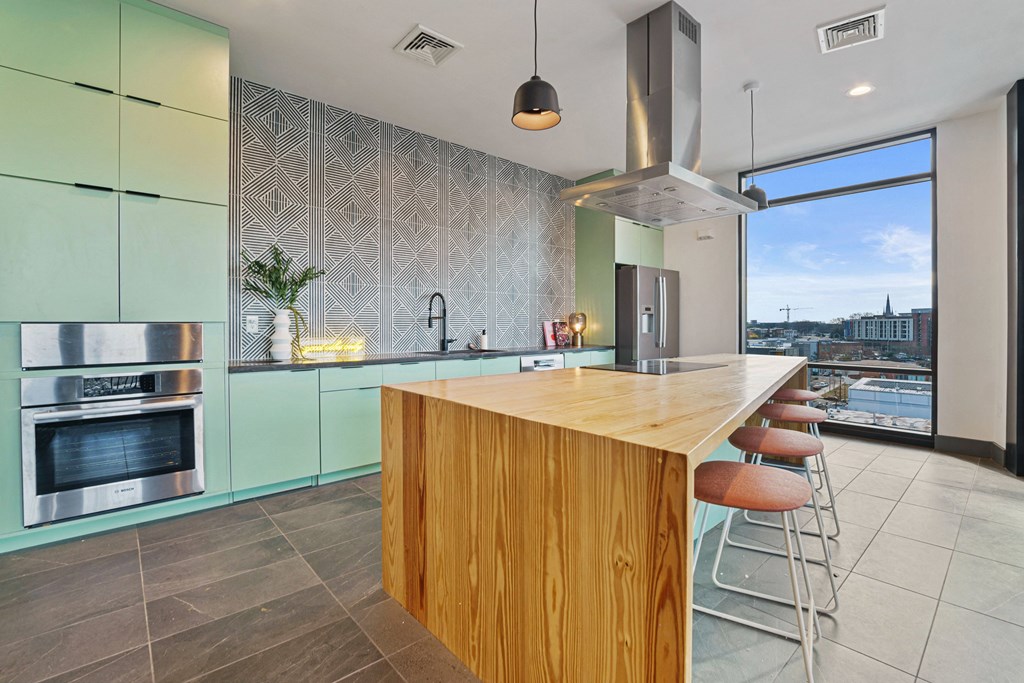 a kitchen with green cabinets and a wooden counter top