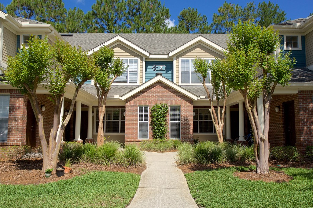 a pathway in front of a house with trees