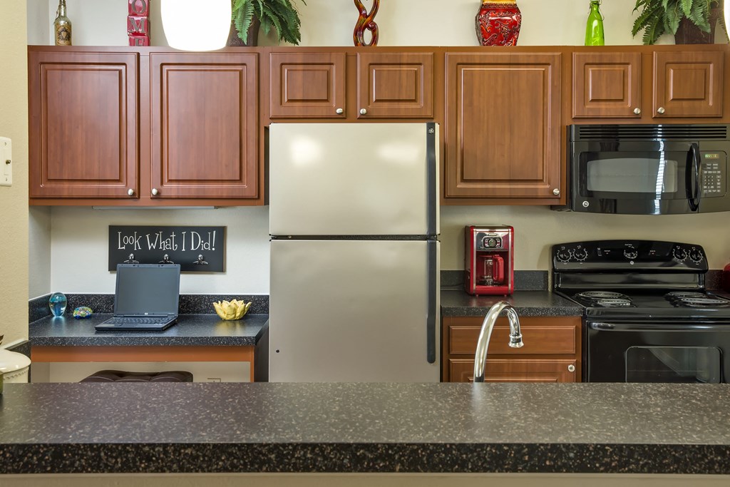 a kitchen with a granite counter top and a stainless steel refrigerator