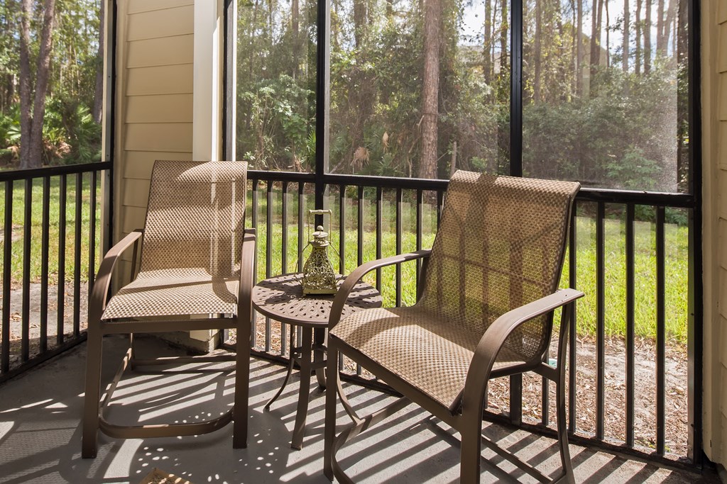 a porch with two chairs and a table on a balcony