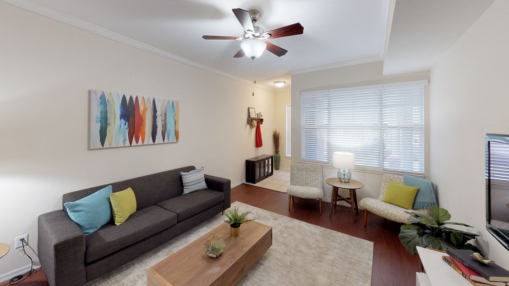 a living room with a couch and a ceiling fan