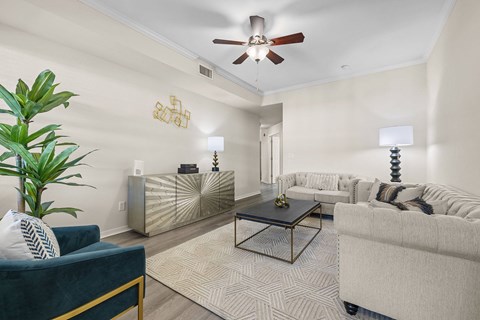 A living room with a blue couch, a coffee table, and a ceiling fan.