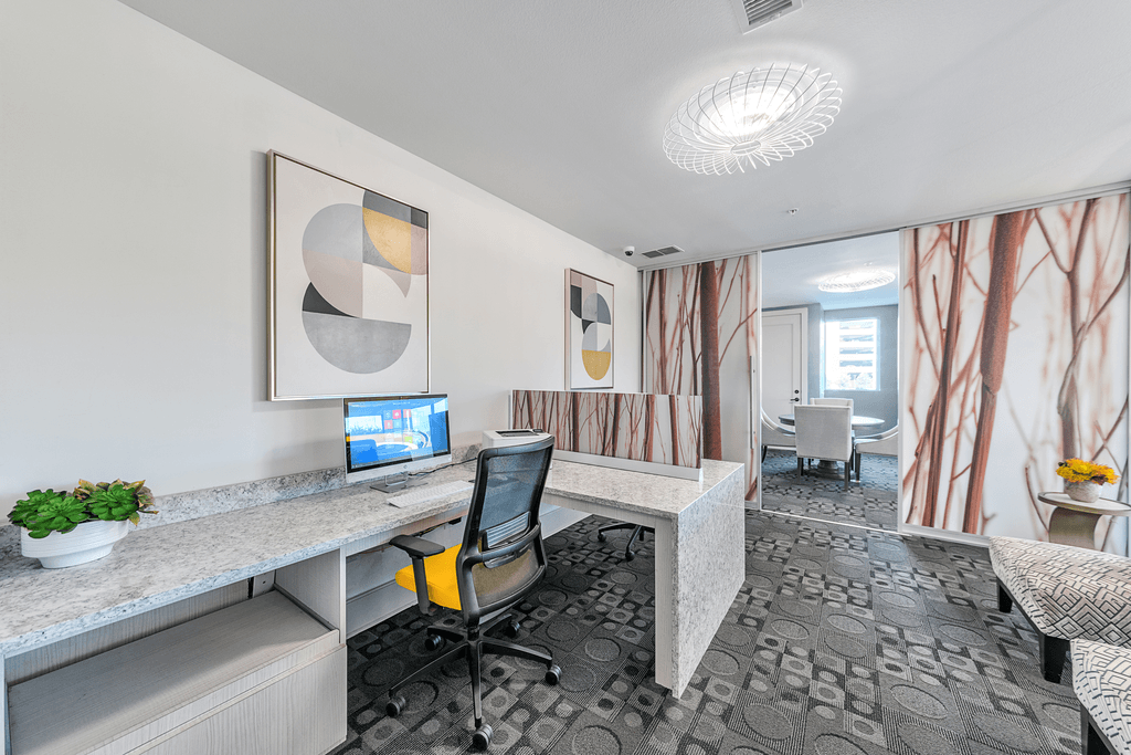A modern office with a grey desk and a computer on it.