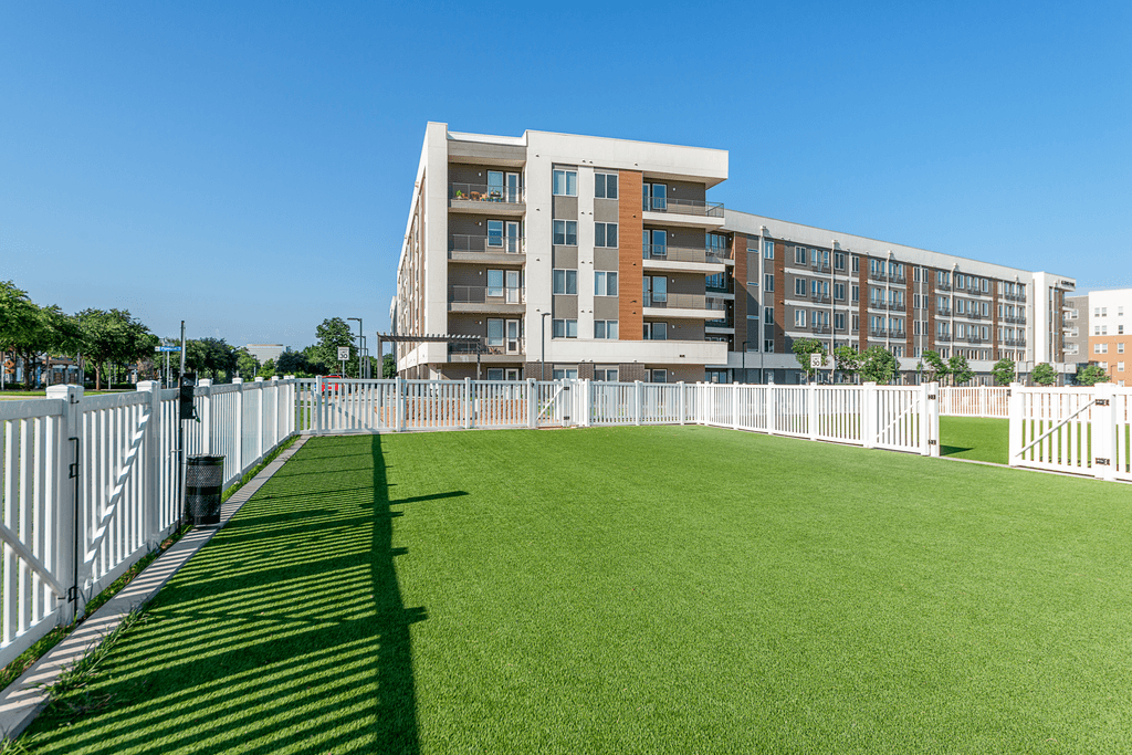 A large building with a white fence in front of it.