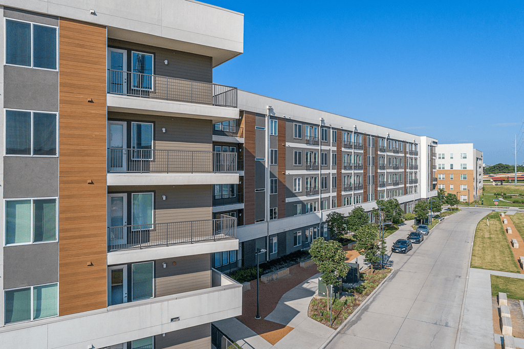 A modern apartment complex with a mix of wood and concrete exterior.