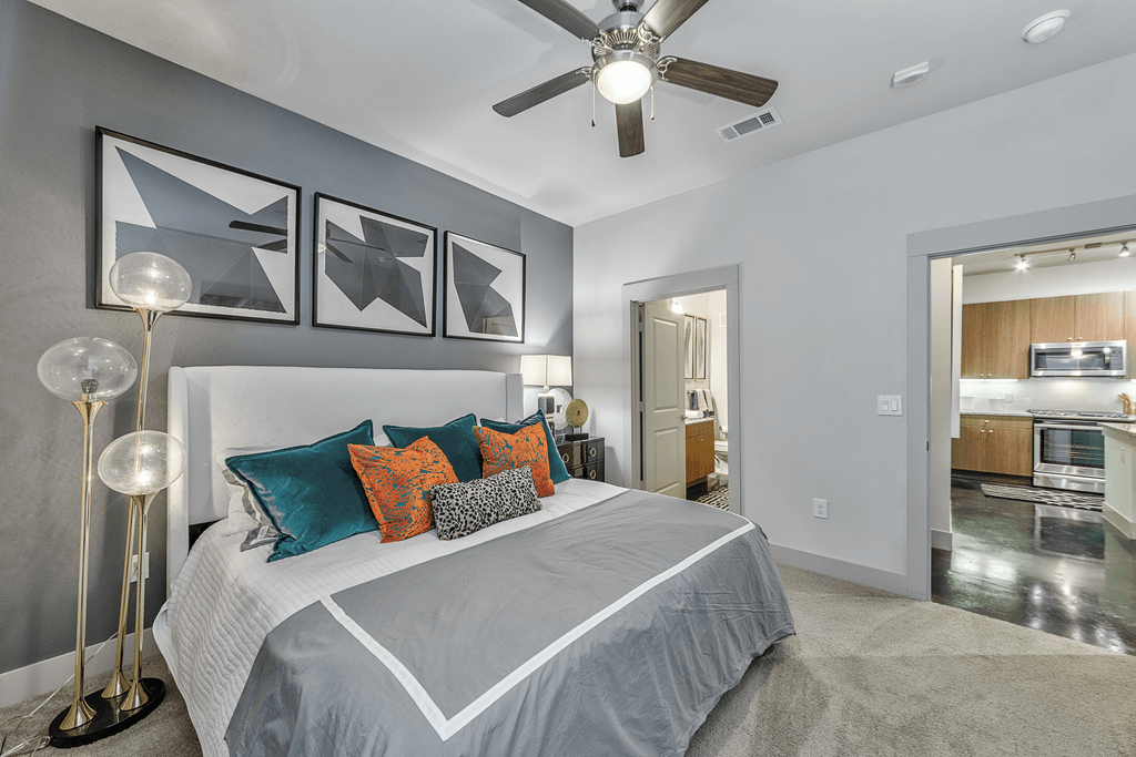 A bedroom with a large bed and a ceiling fan.