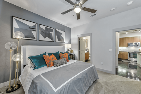 A bedroom with a large bed and a ceiling fan.