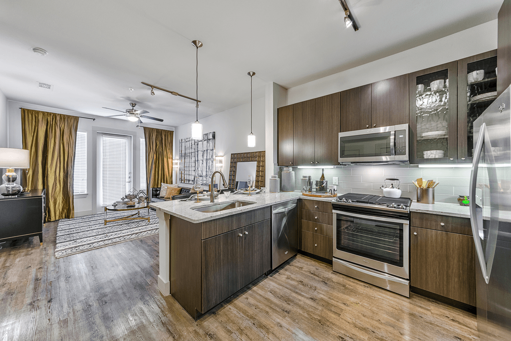 A modern kitchen with wood floors and stainless steel appliances.