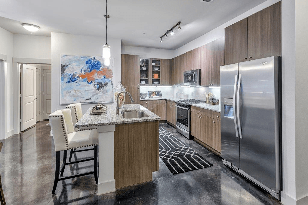 A modern kitchen with a large island and stainless steel appliances.