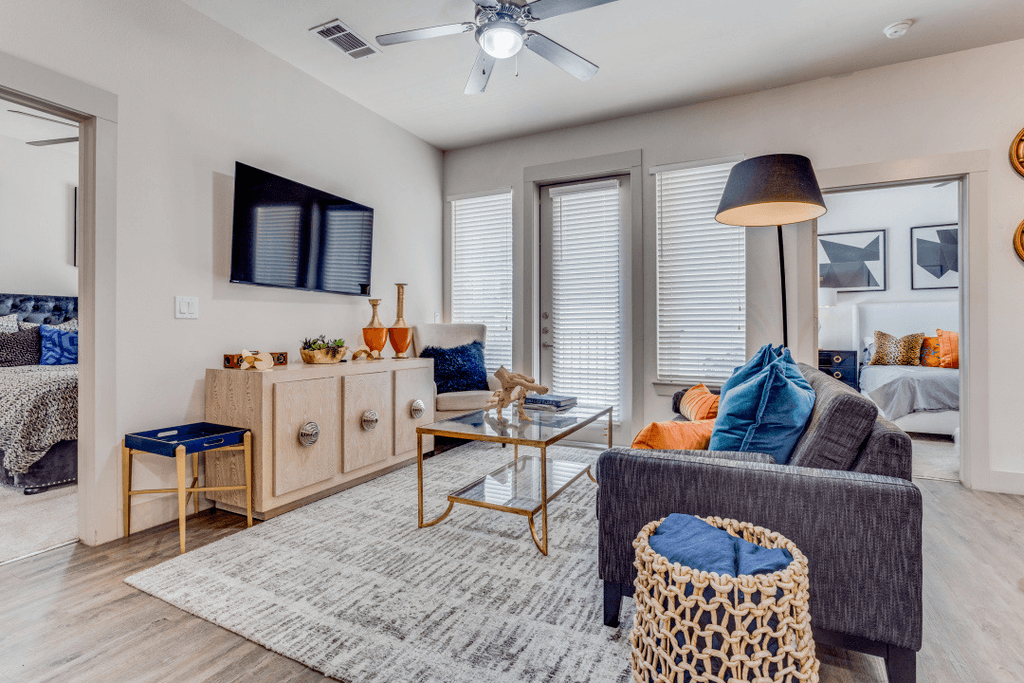 A living room with a grey couch, a wooden cabinet, a coffee table, and a rug.