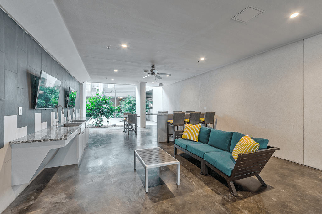 A modern living room with a green sofa and a glass table.
