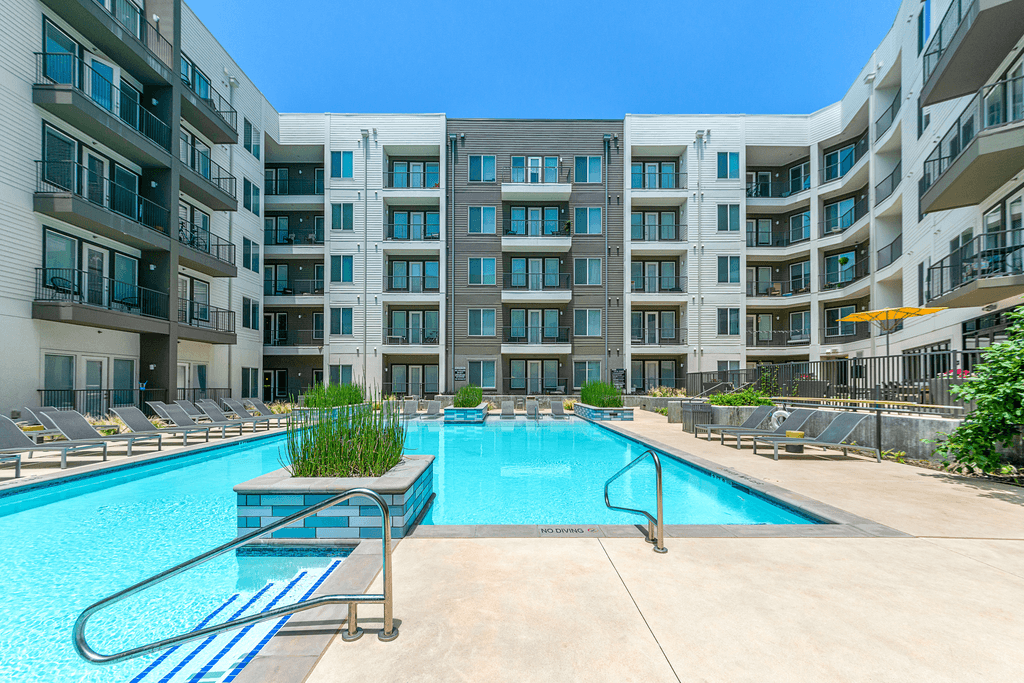 A swimming pool in front of apartment buildings.