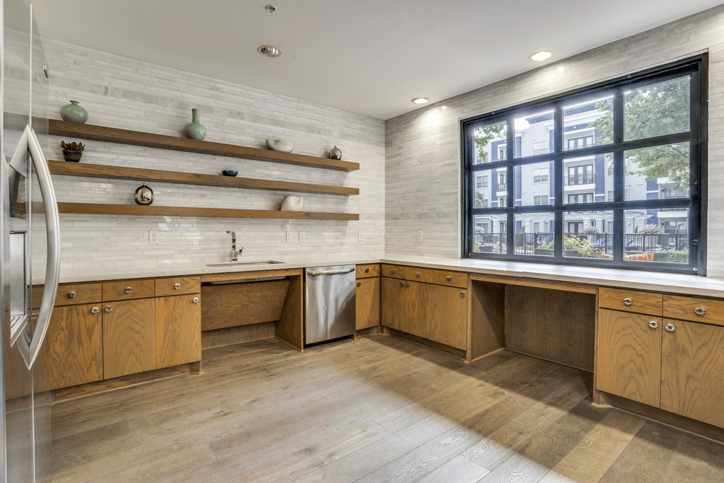 A kitchen with wooden cabinets and a large window.