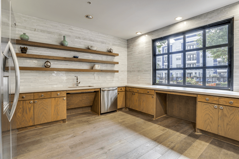 A kitchen with wooden cabinets and a large window.