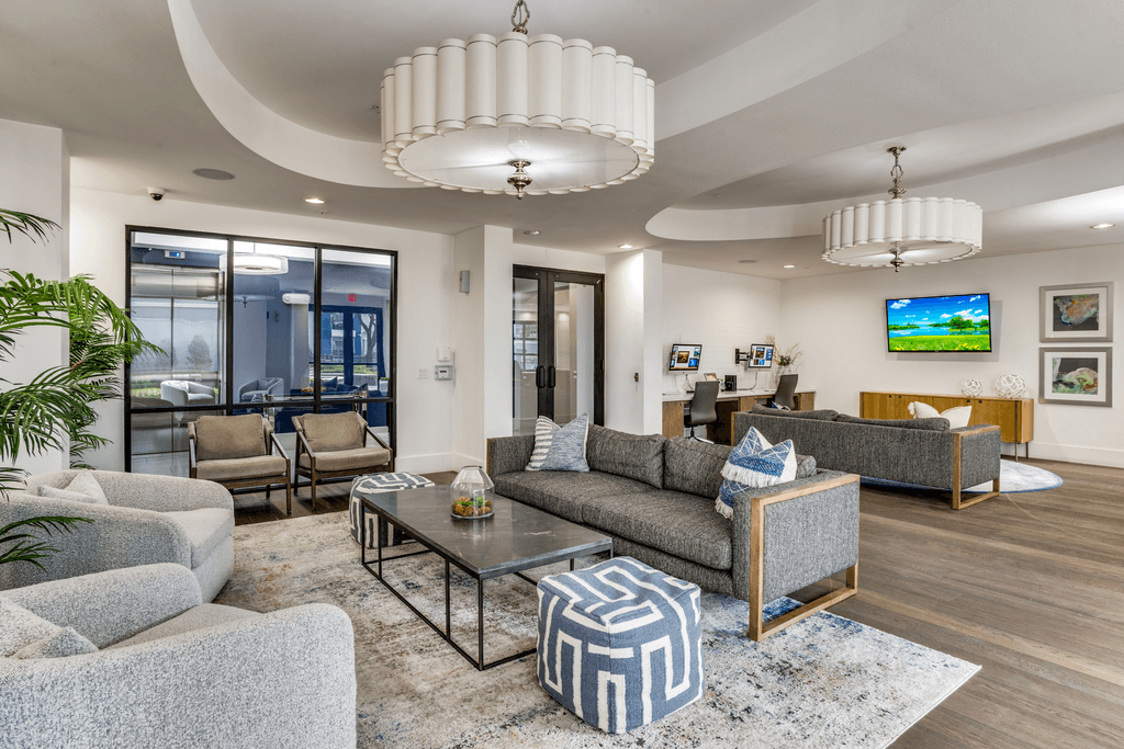A living room with a grey sofa and a glass coffee table.