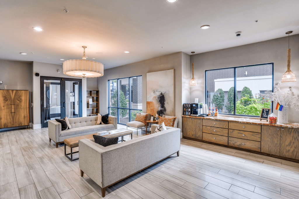 A modern living room with a large grey sofa and wooden flooring.