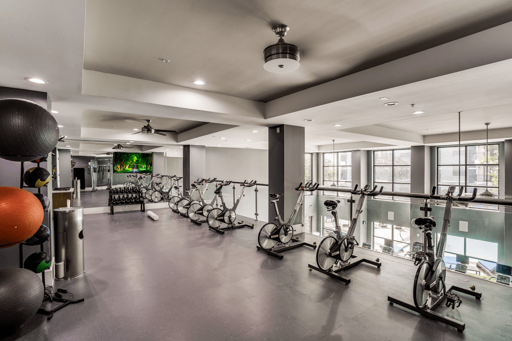 A gym with exercise bikes and a ball.