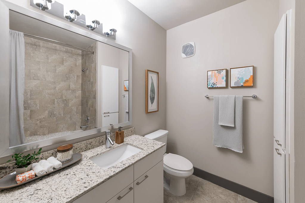 A bathroom with a toilet, sink, and shower.