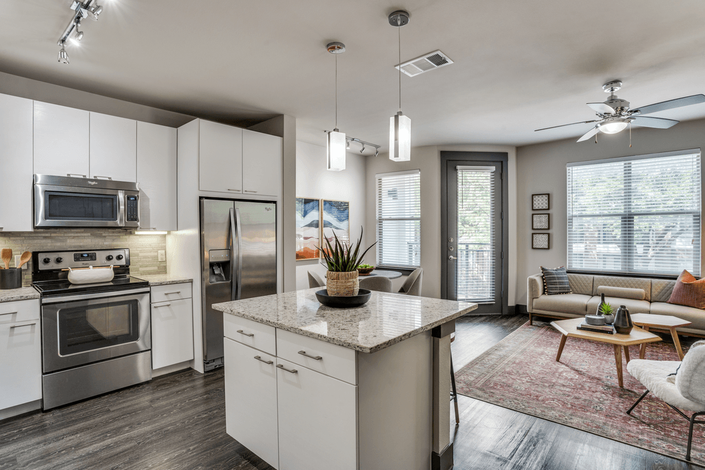 A modern kitchen with stainless steel appliances and white cabinets.