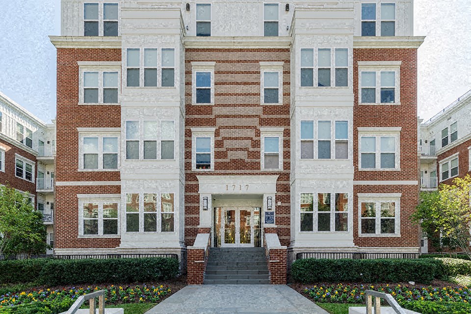 the front of a brick building with a sidewalk in front of it