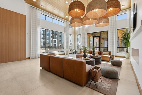 A modern living room with a large sectional sofa and a wooden ceiling.