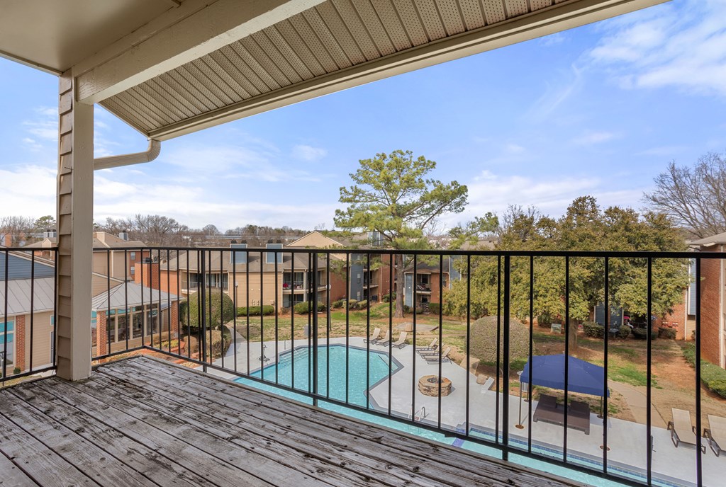 the view of a pool from a balcony with a fence