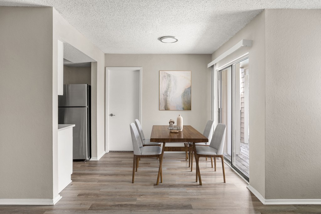 a dining room with a wooden table and chairs and a window