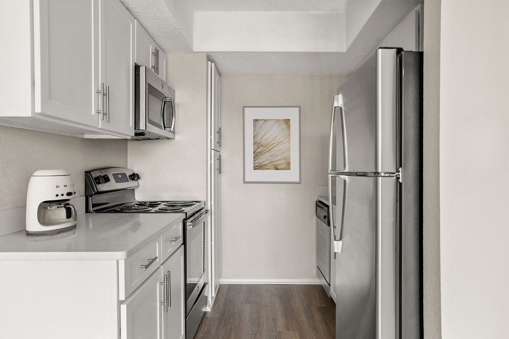 a kitchen with stainless steel appliances and white cabinets