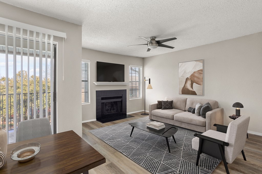 an open living room with a fireplace and a ceiling fan