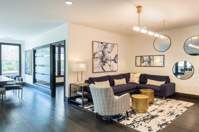 a living room with a couch and chairs and a dining room table