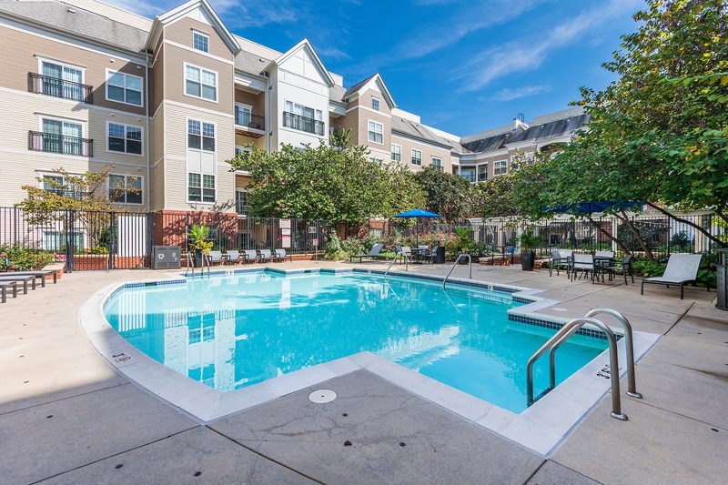 a swimming pool with an apartment building in the background