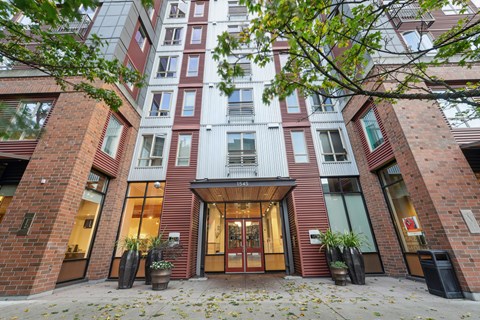 A modern building with a glass facade and a wooden entrance.