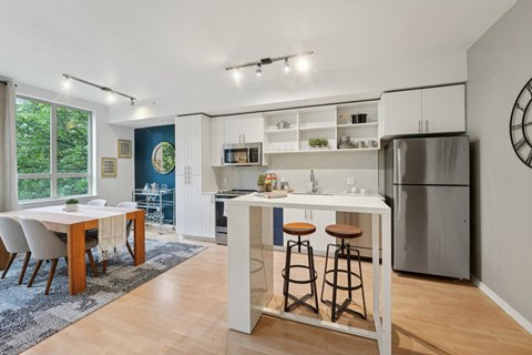 A kitchen with a table and chairs in front of a window.