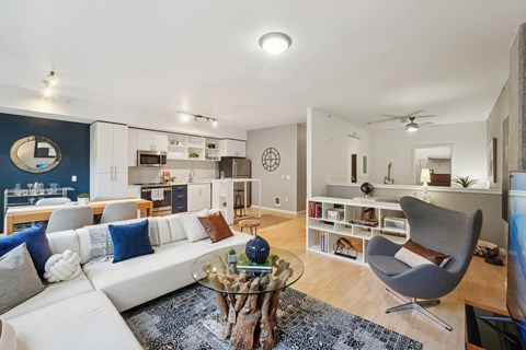 A modern living room with a white couch and a glass coffee table.