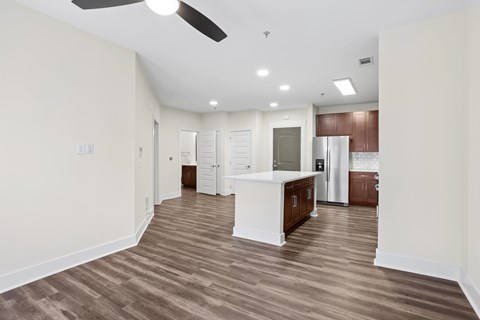 A spacious kitchen with a white countertop and wooden flooring.