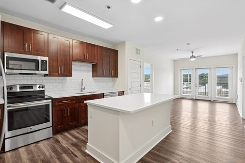A kitchen with wooden cabinets and a white island.