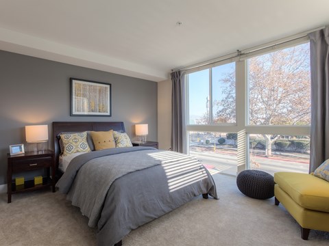 A bedroom with a large bed and a yellow chair.